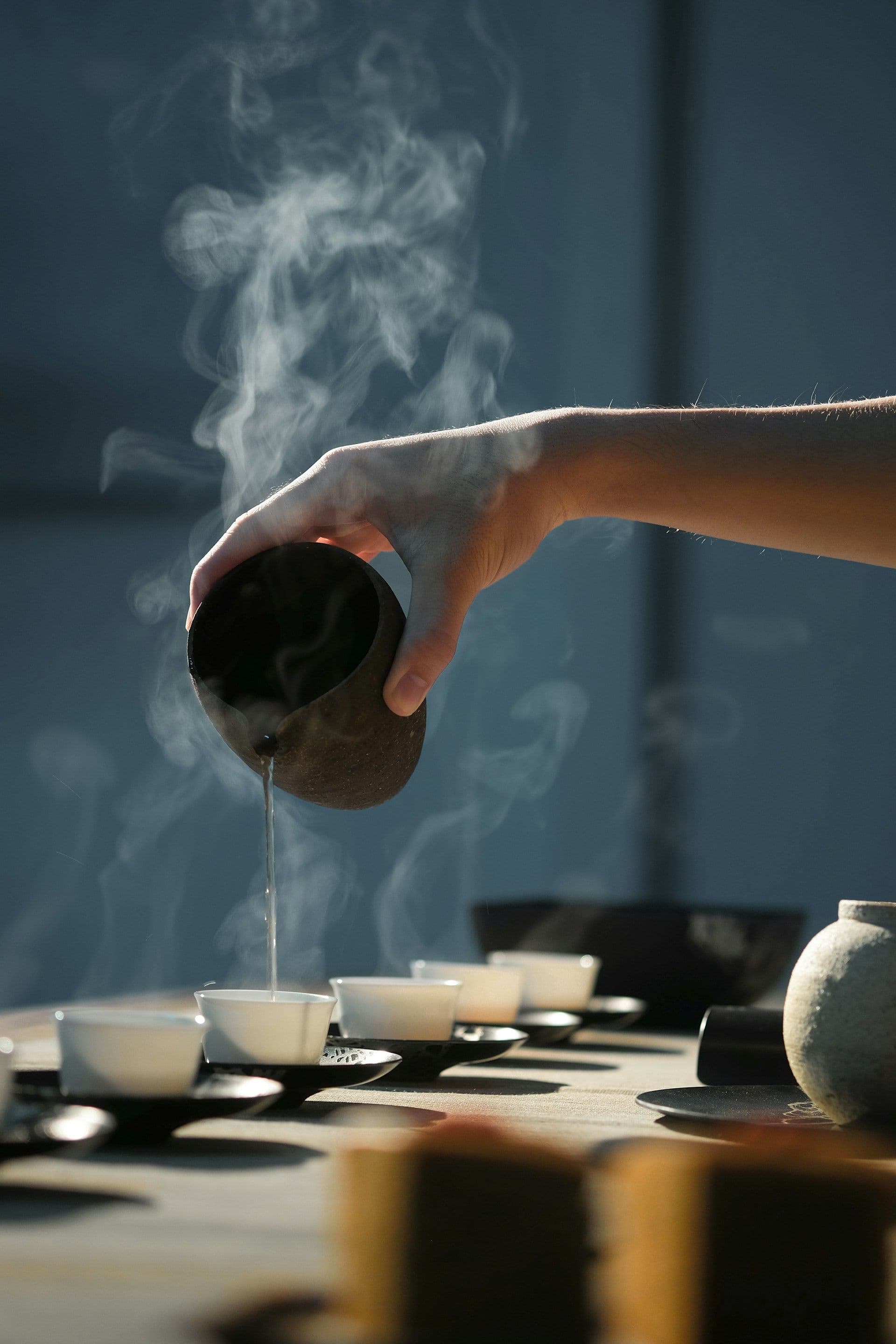 A steaming cup of Mullein Leaf Tea on a wooden table with mullein leaves.